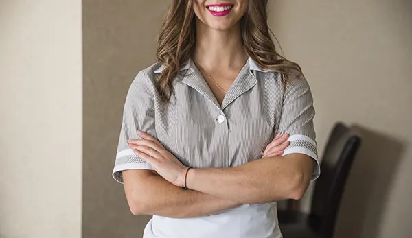 primer-plano-de-la-camarera-sonriente-de-pie-con-los-brazos-cruzados